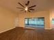 Open-concept living area with wood-look floors, fan and sliding glass door leading to the patio at 6153 La Pine Rd, Brooksville, FL 34602
