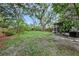 A spacious backyard with mature trees and a screened-in lanai, perfect for outdoor living at 6263 Oak Cluster Cir, Tampa, FL 33634