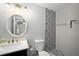 Nicely updated bathroom with a round mirror, modern vanity, and decorative tile work at 6263 Oak Cluster Cir, Tampa, FL 33634