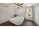 Cozy bedroom with wood-look floors, ceiling fan, and a window letting in natural light at 6263 Oak Cluster Cir, Tampa, FL 33634