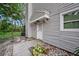 Side entrance to home with stepping stones, landscaping, and gray siding at 6263 Oak Cluster Cir, Tampa, FL 33634