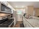 Bright kitchen featuring granite countertops, stainless steel appliances, and ample counter space at 6263 Oak Cluster Cir, Tampa, FL 33634