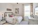 Cozy bedroom with soft decor, a comfortable bed, a bright window, and charming floral accents at 6413 Gladeview Way, Land O Lakes, FL 34638