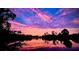 Scenic view of a serene pond reflecting a colorful sunset sky with silhouettes of trees at 6912 14Th N St # 6912, St Petersburg, FL 33702