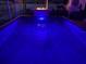 Inviting pool illuminated with blue lights and a fire feature, ideal for relaxation at 6912 14Th N St # 6912, St Petersburg, FL 33702