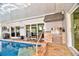 Outdoor kitchen with a built-in grill adjacent to a sparkling pool, perfect for entertaining at 6912 14Th N St # 6912, St Petersburg, FL 33702