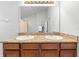 Bathroom featuring double vanity, granite countertop, large mirror, and wood cabinets at 7001 Interbay Blvd # 192, Tampa, FL 33616