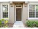 Inviting front entryway featuring a brown door with sidelight windows and neutral stucco facade at 7001 Interbay Blvd # 192, Tampa, FL 33616