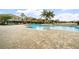 Community swimming pool with lounge chairs, landscaping, and lake views at 7001 Interbay Blvd # 192, Tampa, FL 33616