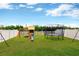 Large backyard featuring a trampoline, a playset, and a privacy fence at 7017 Gomez Rocks Ct, Sun City Center, FL 33573