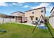 Landscaped backyard featuring a patio, swings, and ample green space for outdoor enjoyment at 7017 Gomez Rocks Ct, Sun City Center, FL 33573
