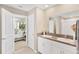 Bathroom featuring a double vanity with granite countertops, and access to a bedroom at 7017 Gomez Rocks Ct, Sun City Center, FL 33573