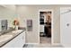 Bathroom featuring a double sink vanity, a walk-in shower, and a neatly organized walk-in closet at 7017 Gomez Rocks Ct, Sun City Center, FL 33573