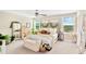 Bright and airy main bedroom with a decorative headboard, bench, and natural light from large windows at 7017 Gomez Rocks Ct, Sun City Center, FL 33573