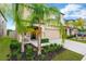 Beautiful two-story home with a well-manicured lawn and tropical landscaping, adding curb appeal and charm at 7017 Gomez Rocks Ct, Sun City Center, FL 33573