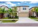 Two-story home with a two-car garage, well-manicured lawn, and fresh landscaping at 7017 Gomez Rocks Ct, Sun City Center, FL 33573