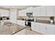 Modern kitchen featuring stainless steel appliances, granite countertops, and white cabinets at 7017 Gomez Rocks Ct, Sun City Center, FL 33573