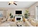 Cozy living room featuring an electric fireplace, a ceiling fan, and lots of natural light at 7017 Gomez Rocks Ct, Sun City Center, FL 33573