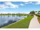 Scenic community pond with a walking path and lush landscaping, offering a tranquil outdoor space for residents at 7017 Gomez Rocks Ct, Sun City Center, FL 33573