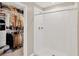 Well-organized walk-in closet with shelving and rods, adjacent to a modern walk-in shower at 7017 Gomez Rocks Ct, Sun City Center, FL 33573
