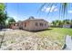 View of the backyard of the home with an open yard, grassy areas, and partial fencing at 7676 18Th St N, St Petersburg, FL 33702