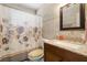 Well-maintained bathroom with decorative shower curtain, granite countertop, and warm earth-toned tile at 7676 18Th St N, St Petersburg, FL 33702