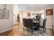 Dining area with wood floors, a decorative area rug, and a glimpse into the adjacent kitchen at 7676 18Th St N, St Petersburg, FL 33702