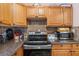 Functional kitchen with wooden cabinetry, modern appliances, and durable granite countertops at 7676 18Th St N, St Petersburg, FL 33702