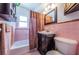 Compact bathroom with pink tile, a dark vanity, and a combined tub and shower at 841 4Th N Ave # 21, St Petersburg, FL 33701