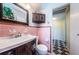 A classic bathroom with vintage pink tile, dark wood vanity, and decorative mirror at 841 4Th N Ave # 21, St Petersburg, FL 33701