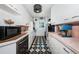 Efficient kitchen with white cabinets, black and white tile floors, and pink tile backsplash at 841 4Th N Ave # 21, St Petersburg, FL 33701
