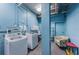 Functional laundry area equipped with modern washer and dryer, including seating, set against a blue-painted wall at 841 4Th N Ave # 21, St Petersburg, FL 33701