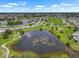 Expansive aerial view showcases the large pond surrounded by walking trails and residential areas at 913 Augusta Dr, Sun City Center, FL 33573