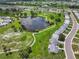 Overhead view of a community featuring a pond, walking trails, and well-kept homes at 913 Augusta Dr, Sun City Center, FL 33573