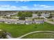 Aerial view of a quiet neighborhood with manicured lawns, winding streets, and a tranquil lake at 913 Augusta Dr, Sun City Center, FL 33573