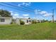 View of home's backyard and exterior with lush lawn at 913 Augusta Dr, Sun City Center, FL 33573