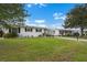 White single-story homes with black shutters, green lawn, and a shared driveway at 913 Augusta Dr, Sun City Center, FL 33573