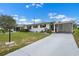 Well-maintained home with lush green lawn and a painted driveway leading to covered carport and entry at 913 Augusta Dr, Sun City Center, FL 33573