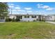 A cozy white single-story home with a well-kept green lawn and minimal landscaping at 913 Augusta Dr, Sun City Center, FL 33573
