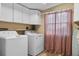 Laundry room with white cabinets, washer and dryer, and tile flooring at 913 Augusta Dr, Sun City Center, FL 33573