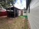 Backyard with a screened-in patio, exterior door, and green turf at 9218 N 52Nd St, Tampa, FL 33617