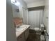 Bathroom featuring shower-tub combo, toilet, and single sink vanity with ample lighting at 9218 N 52Nd St, Tampa, FL 33617
