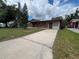 Single-story home with a long driveway and brick accents at 9218 N 52Nd St, Tampa, FL 33617