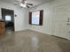 Bright living room featuring light walls, a ceiling fan, and a window with wooden shutters at 9218 N 52Nd St, Tampa, FL 33617