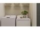 Functional laundry room with side-by-side washer and dryer, plus storage shelves at 9364 Bonita Mar Dr, Parrish, FL 34219
