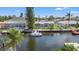 Aerial view of waterfront home showcasing its boat dock, lush landscaping and a private pool at 9917 San Sierra Way, Port Richey, FL 34668