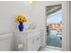Bright bathroom with a white vanity and a vase of sunflowers, leading to a screened pool area at 9917 San Sierra Way, Port Richey, FL 34668