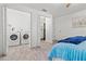 Bedroom featuring a washer, dryer, a closet with shelving, and a comfortable bed with blue blanket at 9917 San Sierra Way, Port Richey, FL 34668