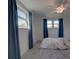 Bright bedroom with two windows, fan, and blue drapes, offering a serene and calming atmosphere at 9917 San Sierra Way, Port Richey, FL 34668