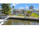 Waterfront home featuring a screened lanai, wooden deck with pergola, and a private dock at 9917 San Sierra Way, Port Richey, FL 34668